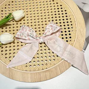 Macro view of a vintage French pink floral hair ribbon featuring "Positive Thinking" text.