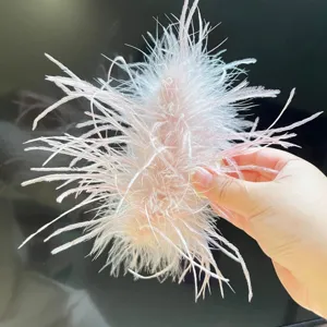 Detailed macro view of a light pink ostrich feather hair claw clip with fluffy texture