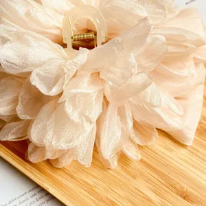 Dettaglio ravvicinato dell'elegante fiore in tessuto 3D su una grande molletta per capelli