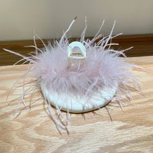 Detailed macro view showing the soft texture of pink ostrich feather on a white hair claw clip