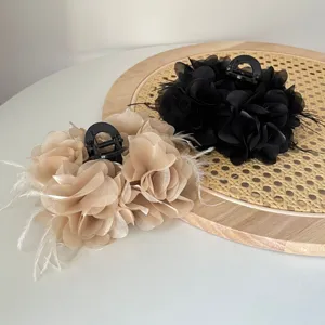 Stijlvolle haarclips van stoffen bloemen met veren in zwart en champagne beige