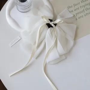 Detailed view of an elegant white chiffon bow hair claw clip featuring soft texture