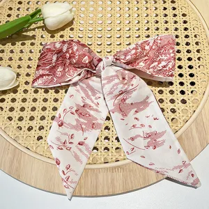 Close-up of a vintage French silk-like hair ribbon with red botanical print on rattan
