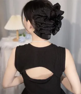 Detailed view of black shimmer bubble cloud bow hair claw clip on model's hair