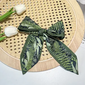 Detail of vintage French green hair ribbon featuring intricate botanical fern leaf prints