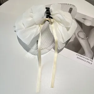 Detailed macro shot of large white textured chiffon bow hair claw clip for women