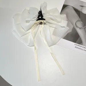 Detailed view of an elegant white tiered chiffon bow hair claw clip with long ribbons