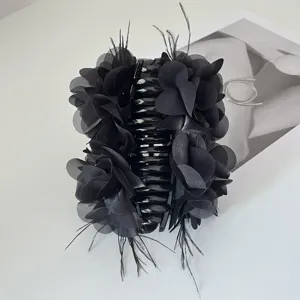 Detailweergave van de handgemaakte zwarte stoffen bloemen haarklem met veren