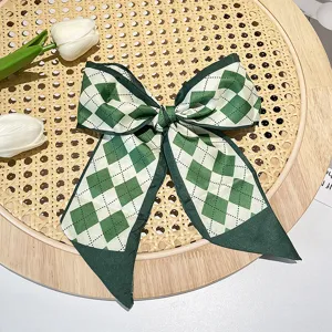Detail view of retro French green argyle printed hair ribbon scarf with elegant bow design