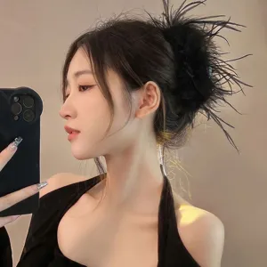 Detailed view of an elegant black ostrich feather hair claw clip for a stylish updo