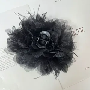 Detailansicht einer eleganten schwarzen Stoffblumen-Haarklammer mit Straußenfedern