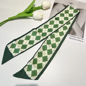 Detailed view of green argyle pattern skinny silk scarf on white surface with tulips