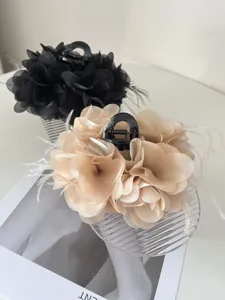 Detailopname van haarklemmen met organza bloemen en delicate veren accenten