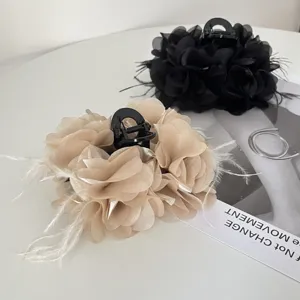 Gedetailleerde weergave van elegante stoffen bloem haarklemmen met veer accenten