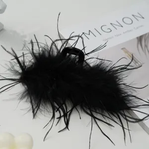 Detail view of an elegant black ostrich feather hair claw clip for women's hair styling.