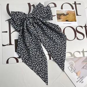 Détail d'une pince à cheveux à nœud floral noir et blanc avec de longs rubans élégants
