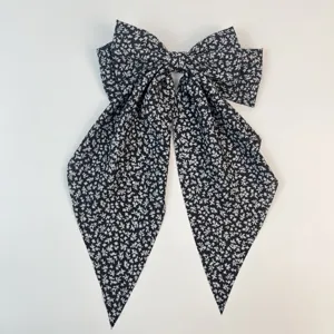 Vue détaillée de la grande pince à cheveux à nœud noir avec imprimé floral et rubans