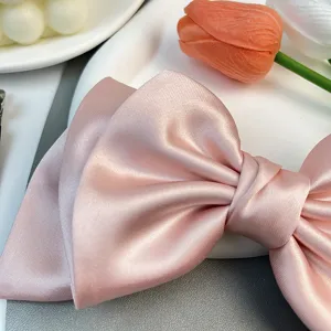 Detailed close-up showing the smooth satin texture of a elegant pink bow hair clip