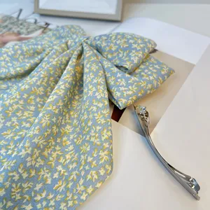 Détail d'une élégante pince à cheveux à nœud floral bleu avec longs rubans et barrette