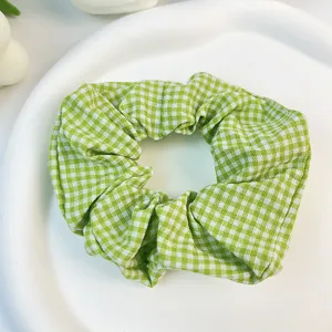 Primer plano de un coletero de algodón a cuadros verdes y blancos sobre blanco