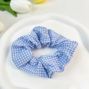 Primer plano de un coletero de algodón a cuadros azules y blancos en un plato blanco