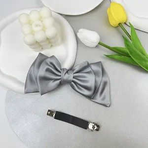 Detail view showing the elegant gray satin bow front and sturdy metal spring clip back