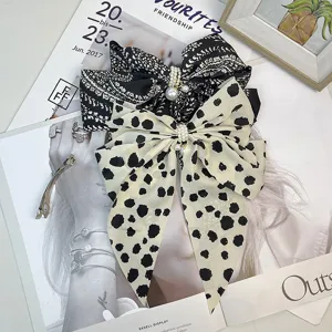 Detail view of retro bow hair clips with elegant pearl charms and patterned fabric