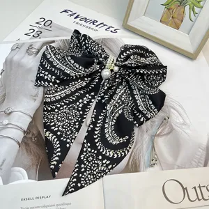 Detailed view of large retro paisley bow hair clip with elegant pearl accents