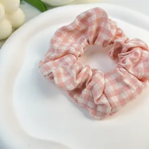 Primer plano de un coletero de algodón a cuadros rosas y blancos en un plato blanco