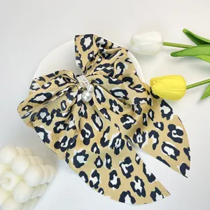 Elegant leopard print bow hair clip featuring white pearls for vintage hair styling