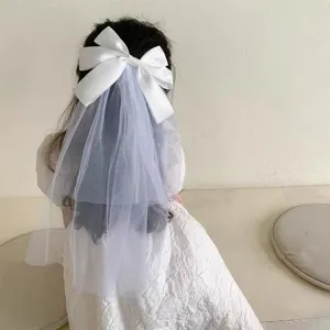 Detailed rear view of white silk bow hair clip with tiered tulle veil for girls