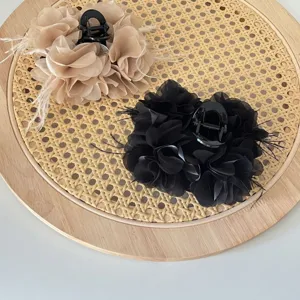 Detailweergave van hippe handgemaakte stoffen bloemen haarklemmen met lichte veren