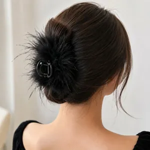 Elegant black ostrich feather hair claw clip worn on a woman's updo bun hairstyle