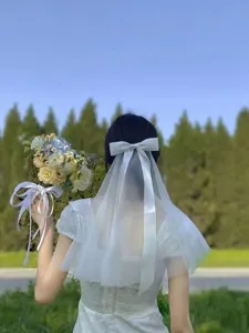 Elegant white mesh hair veil with large satin bow for girls, perfect for flower girl look