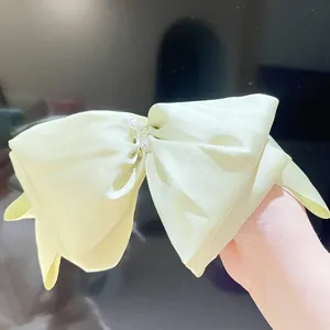 Close-up detail of the oversized pearl satin French bow hair clip with pearl center