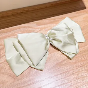 Elegant pearlescent satin French bow hair clip with pearls and sparkling rhinestones.
