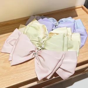 Variety of pastel satin French bow hair clips with pearls and rhinestones on display