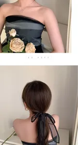 Gedetailleerde weergave van een elegante zwarte organza haarband met een strik.