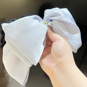 Detailed view of the pearl and crystal decoration on this oversized satin bow hair clip