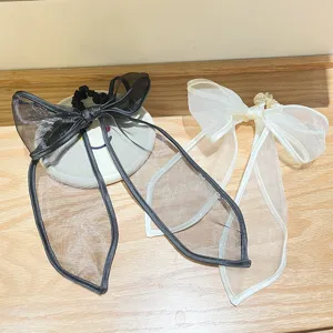 Detailopname van elegante zwart-witte organza strik scrunchies op houten oppervlak
