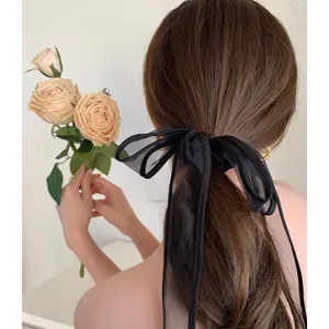 Gedetailleerde close-up van een grote elegante zwarte organza haarelastiek met strik