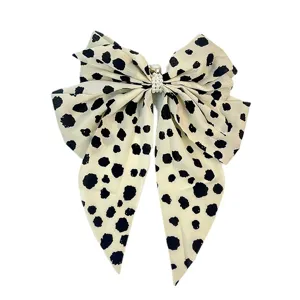 Large cream bow hair clip with black dalmatian spots and elegant pearl center decoration