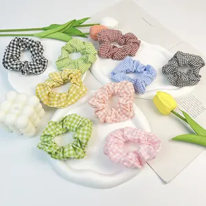Detalle de coleteros de algodón a cuadros de colores en platos blancos ondulados.