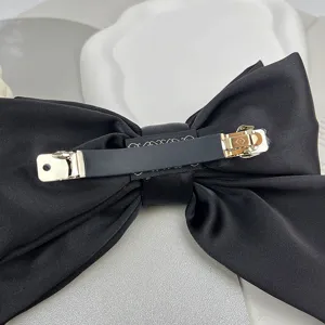 Detailed back view of black satin triple-layer bow hair clip with durable metal clip