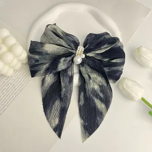Vue détaillée du nœud papillon en mousseline plissée tie-dye orné de perles fines