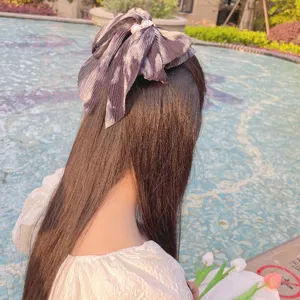 Vue détaillée d'une pince à cheveux nœud en mousseline plissée avec perle tie-dye