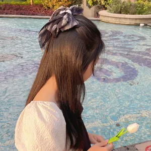 Détail d'une barrette à cheveux nœud en mousseline plissée avec perles dégradées.