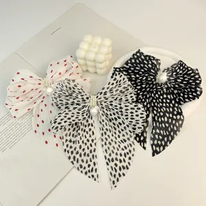 Détail en gros plan de la texture en mousseline plissée et des perles sur les nœuds.