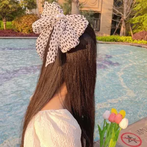 Vue détaillée d'une pince à cheveux en mousseline plissée léopard avec des perles élégantes
