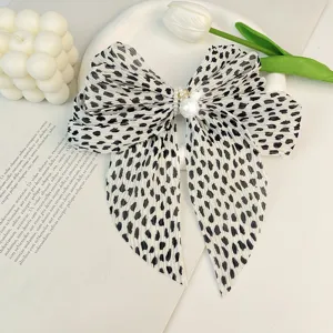Barrette à cheveux élégante en mousseline à pois noirs et blancs avec perles fines.